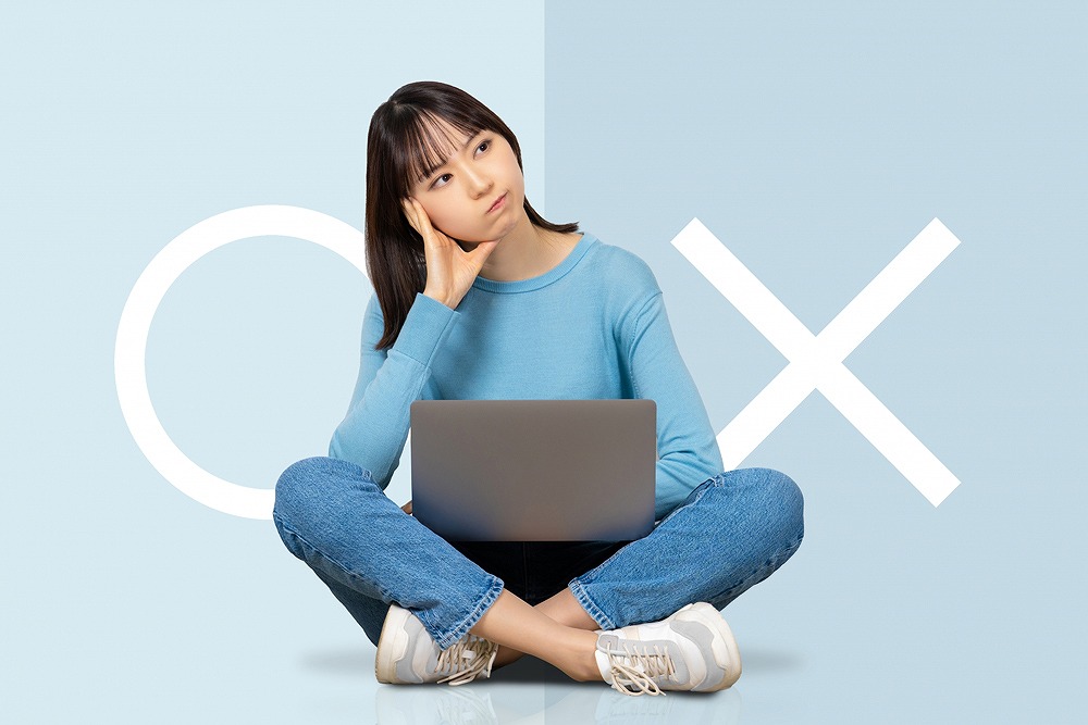 粗大ごみ処分の方法に迷う女性。パソコンを前に収集と持ち込みのどちらが良いか考えている様子